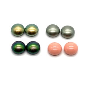 May include: Four pairs of round, polished beads in various colors. The top left pair is gold and green, the top right pair is gray, the bottom left pair is dark green, and the bottom right pair is pink. The beads are on a white background.