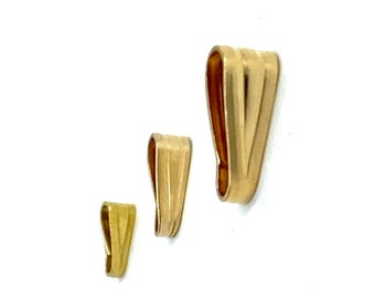 Puede incluir: Tres baúles de colgante de metal de color dorado de diferentes tamaños. Los baúles tienen forma de lágrima con un fondo plano y una parte superior redondeada.
