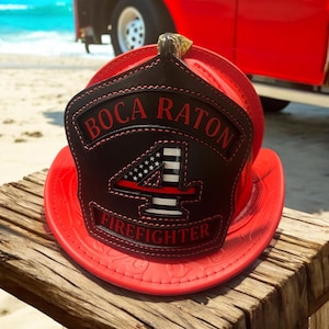 May include: A red leather firefighter helmet with a black leather patch that says "Boca Raton Firefighter" and a number "4" with an American flag design.