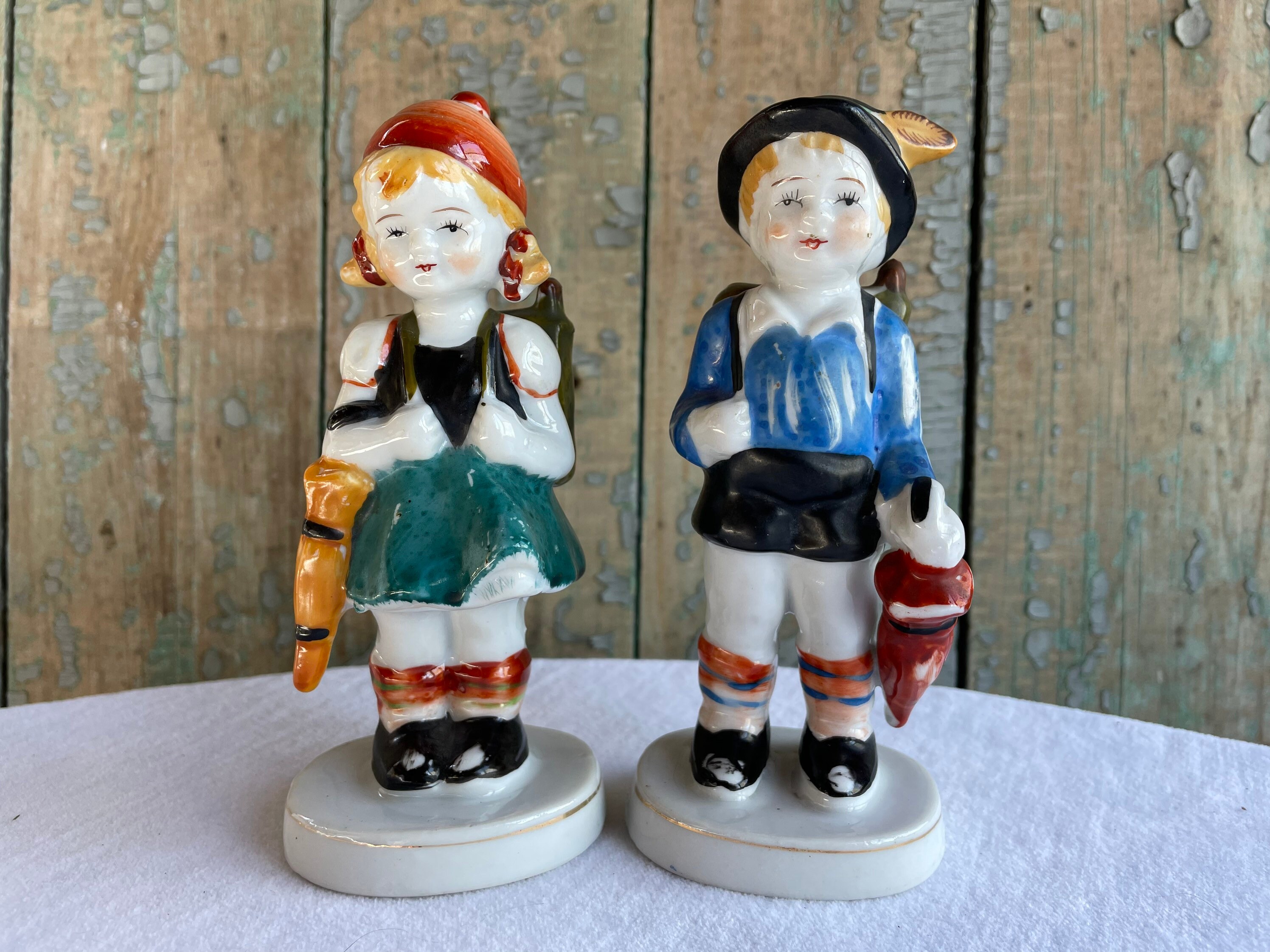 Vintage Boy and Girl China Figurines. Estilo bávaro, ropa alemana. Primer Día de Clases / Mochilas. Cerámica de mediados de siglo, hecha en Japón.