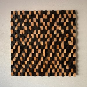 May include: A wall art piece made of wood blocks in a checkerboard pattern. The blocks are stained in two shades of brown, creating a contrasting effect.