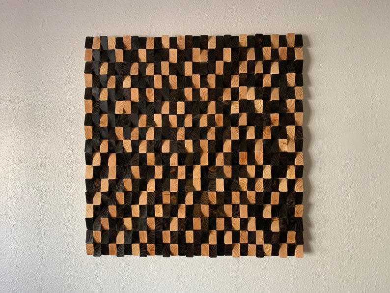 May include: A wall art piece made of wood blocks in a checkerboard pattern. The blocks are stained in two shades of brown, creating a contrasting effect.