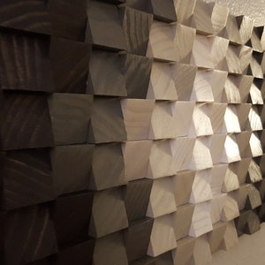 May include: A wall art piece made of wood blocks in various shades of brown and white. The blocks are arranged in a geometric pattern, creating a modern and abstract design.