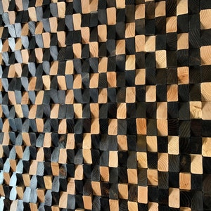 May include: A wall art piece made of wood blocks in a checkered pattern. The blocks are stained in two shades of brown, creating a visually interesting texture.