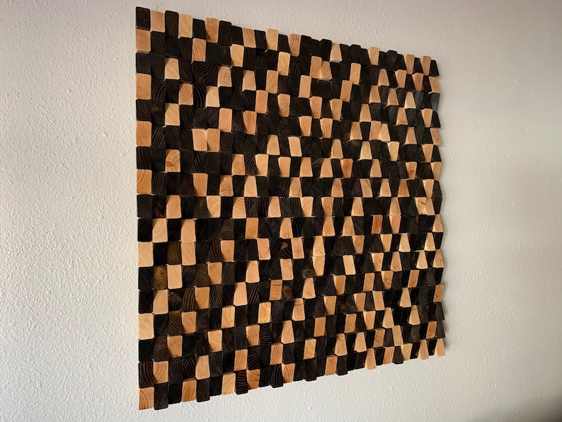 May include: A wall art piece made of wood blocks in a checkered pattern. The blocks are stained in shades of brown and black, creating a geometric design.