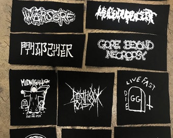 May include: A collection of 12 black fabric patches with white text and graphics. The patches feature band names and logos, including YACOPSIE, MASLAKT, WORSORE, ABENTEUERREICH, 閉邳己訳, GORE BEYOND NECROPSY, MIDNIGH, DEATHHOOK, LIVE FAST DIE GG, 13, SENSELESS APOCALYPSE, and CRIEF.