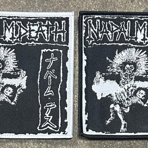 May include: Two black and white embroidered patches with the band name "NAUSEA DEATH" in white lettering. The patches feature a skeletal figure with spiky hair and the Japanese text "ナウゼアデス" in white lettering.