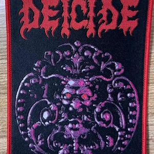 May include: Black and red embroidered patch with the word "DECIDE" in a stylized font. The patch features a detailed, ornate design with a skull-like figure in the center.
