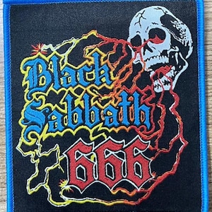 May include: Black Sabbath 666 patch with a skull graphic. The patch features the band's name in blue and yellow lettering, with the number 666 in red. The patch has a black background and a blue border.