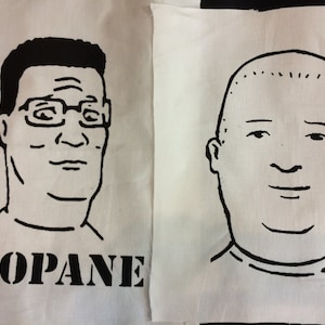 May include: Two black and white line drawings of characters from the TV show King of the Hill. The character on the left is wearing glasses and has the word "PROPANE" printed below. The character on the right is bald.