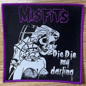 May include: Black and white embroidered patch with the band name "Misfits" in purple lettering. The patch features a skull with a glass of wine and the text "Die Die My Darling".