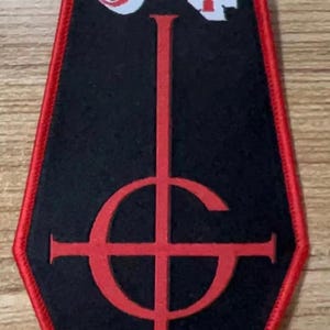 May include: Black and red embroidered patch shaped like a coffin with the word "Ghost" and a cross symbol.