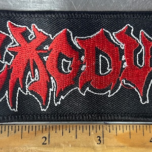 May include: Red and white embroidered patch with the word "EXODUS" in a stylized font on a black background.