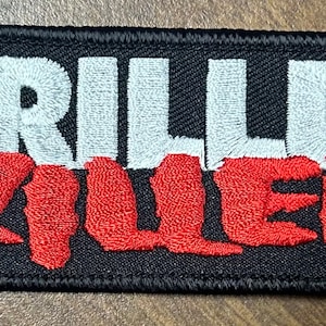 May include: Black embroidered patch with the words "DRILLER KILLER" in white and red lettering.