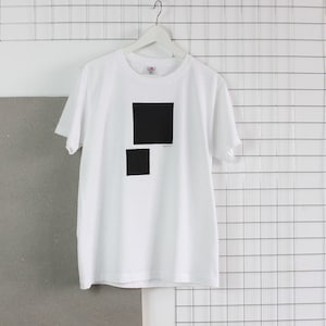 May include: White t-shirt with a black square design on the front. The square is made up of two smaller squares.