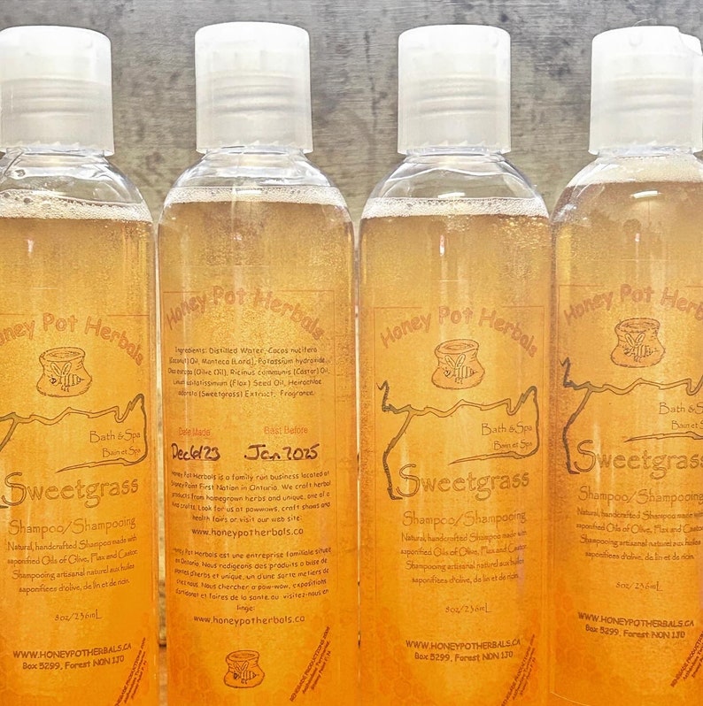 Op de afbeelding: Vier doorzichtige flessen Sweetgrass Shampoo met witte doppen. De etiketten tonen de merknaam, productdetails en ingredi&euml;nten. Elke fles bevat ongeveer 236 ml.