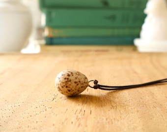 Bird egg pendant: A swallow's egg pendant made from ceramic clay