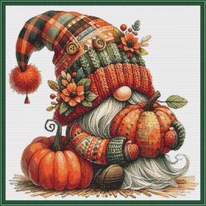 May include: A cross-stitch pattern featuring a gnome wearing a plaid and knit hat with buttons, pom-pom, and floral accents. The gnome has a long white beard and holds a pumpkin, with another pumpkin resting beside it on a straw-like base.