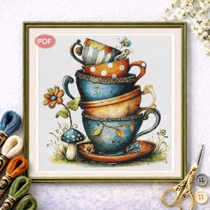Könnte beinhalten: Ein gerahmtes Kreuzstichdesign mit einem Stapel bunter Teetassen. Die Teetassen sind blau, orange und gestreift, mit Blumen- und Punktmustern. Ein Pilz und eine Blume sind ebenfalls enthalten. Das PDF-Logo befindet sich oben links.