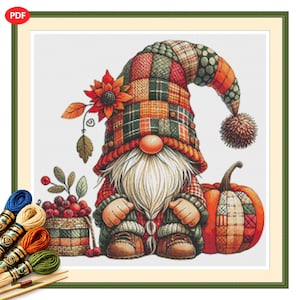 May include: A cross-stitch pattern featuring a gnome with a long white beard, wearing a tall plaid hat with a pom-pom. The gnome is surrounded by a basket of red berries, a sunflower, and a pumpkin with a patchwork design in orange and green.