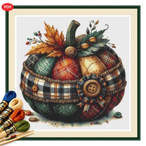 May include: A cross-stitch pattern featuring a pumpkin composed of various plaid fabric patches in shades of red, green, yellow, and blue. The pumpkin is adorned with a large brown button, autumn leaves, and berries. Embroidery floss skeins are visible.