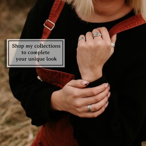 Puede incluir: Una persona lleva un vestido rojo de peto y una camisa negra de manga larga con anillos de plata en los dedos. El texto "Shop my collections to complete your unique look" se muestra en un rect&aacute;ngulo blanco.