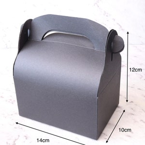 K&ouml;nnte beinhalten: Eine schwarze Pappbox mit einem Griff, die 14 cm x 10 cm x 12 cm misst.