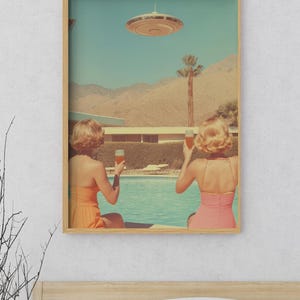 May include: Two people in swimsuits are sitting by a pool, looking up at a flying saucer in the sky. They are holding glasses of orange juice. The scene is set in a desert landscape with palm trees and mountains in the background.