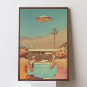 May include: Two women in swimsuits sit by a pool, raising glasses of cocktails, as a flying saucer hovers in the sky above a desert landscape.