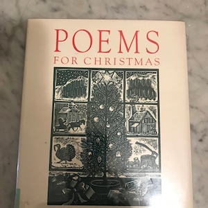 May include: A book titled "Poems for Christmas" with a green and white illustration of a Christmas tree and other holiday scenes. The book is by Neil Philip and illustrated by John Lawrence.
