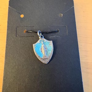 May include: A white ceramic mug with a black handle and the text "But First, Coffee" in a black, handwritten-style font. The mug is on a white surface.