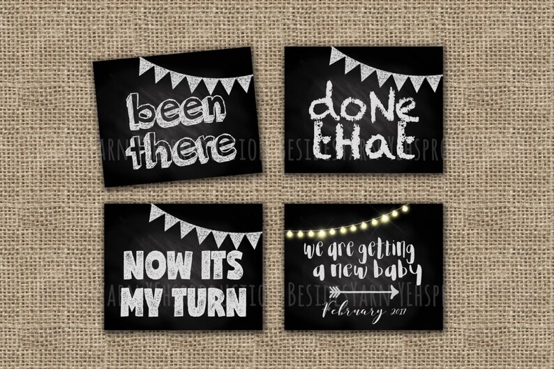 May include: Four black chalkboard signs with white text announcing a new baby. The signs read "been there", "done that", "now it's my turn", and "we are getting a new baby, February 2017".