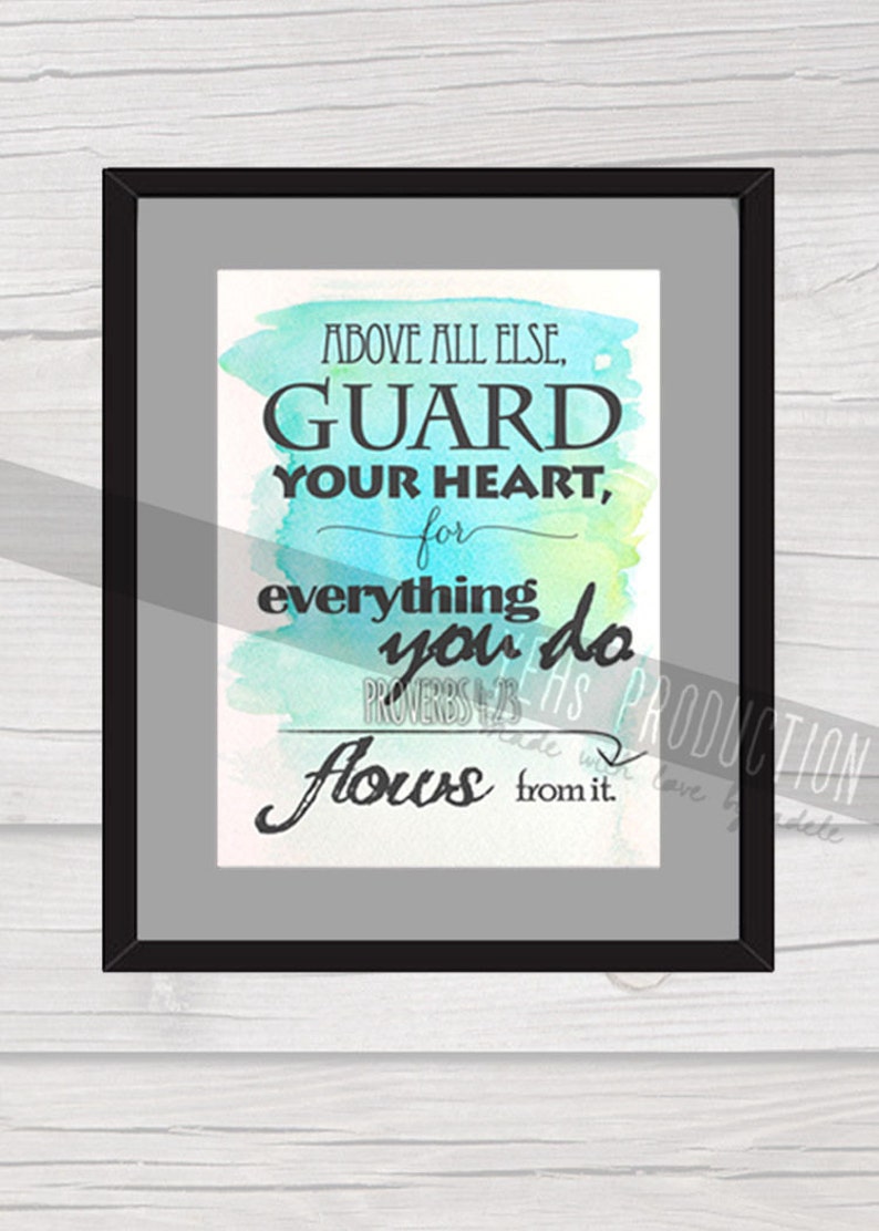 May include: A framed watercolor print with a teal, blue, and green background. The print features the text "ABOVE ALL ELSE, GUARD YOUR HEART, for everything you do flows from it." and the scripture reference "PROVERBS 4:23".
