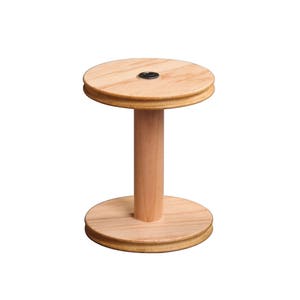 May include: A wooden yarn swift with two circular platforms and a central spindle. The swift is made of light brown wood and has a natural finish.