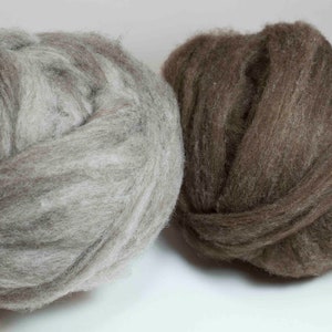May include: Two balls of wool yarn, one is light gray with white streaks and the other is brown.