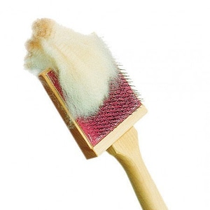 May include: A wooden brush with a red base and a wooden handle. The brush is used for felting wool and has a clump of white wool on top of it.