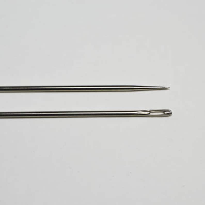 May include: Two silver sewing needles, one with a blunt end and the other with an eye for threading.