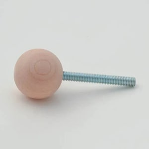 May include: A light pink wooden knob with a silver metal screw.