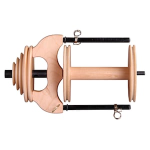 May include: A wooden spinning wheel with a natural finish. The wheel has a large, round bobbin and a smaller, round flyer. The wheel is mounted on a wooden base with a handle.