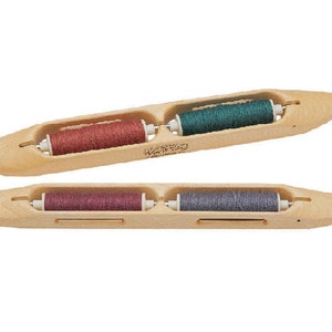 May include: Two wooden bobbins with spools of thread. The top bobbin has green, red, and white thread. The bottom bobbin has purple, gray, and white thread.