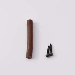 May include: A brown rubber bumper strip and two black screws. The bumper strip is about 3 inches long.