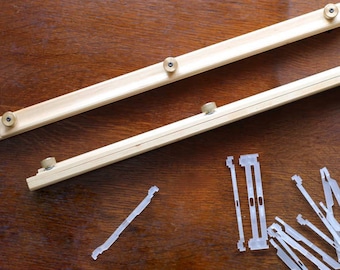 May include: Two wooden stretcher bars with brass knobs and a pile of white plastic canvas stretcher bar clips.