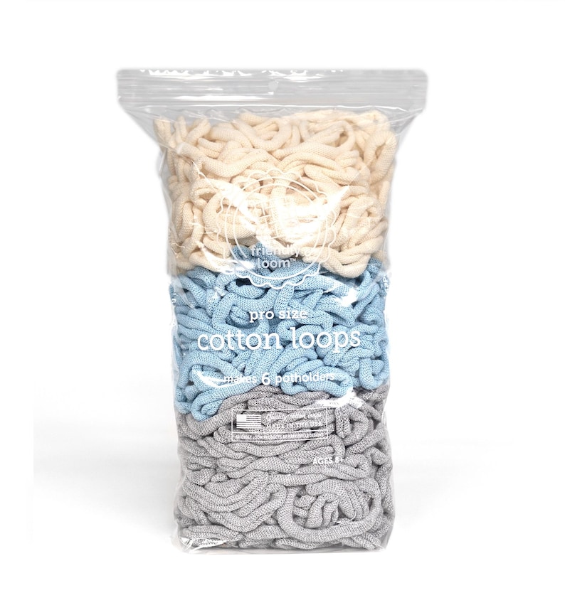 May include: A clear plastic bag filled with cotton loops in three colors: cream, light blue, and gray. The bag has the text "friendly loom" and "pro size cotton loops" printed on it. The loops are for making 6 potholders.