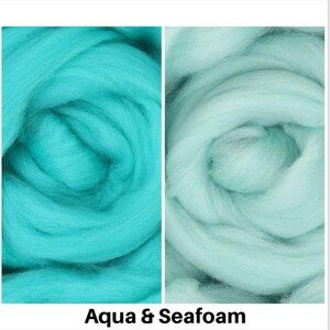 May include: Two swatches of wool roving, one aqua blue and one seafoam green. The wool is soft and fluffy, perfect for felting or spinning.