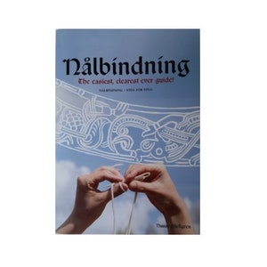 May include: A book titled "Nålbindning: The easiest, clearest ever guide!" with a white and blue illustration of a knot pattern on the cover. The book is about needle binding, a traditional craft.