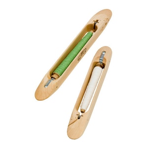 May include: Two wooden bobbins for weaving, one with green thread and one with white thread.