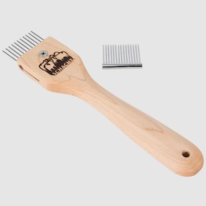 May include: A wooden Schacht weaving comb with metal tines and a separate comb. The comb has a long handle with a hole at the end. The Schacht logo is printed on the comb's head.