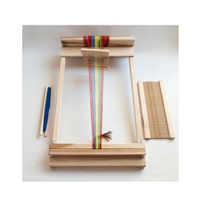 May include: A wooden loom with a rainbow of threads strung across it. The loom is assembled and ready to be used. It comes with a shuttle and a comb.