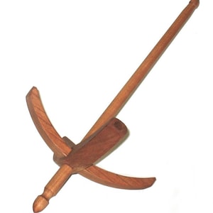 May include: A wooden yarn swift, a tool for winding yarn into a skein. The swift is made of light and dark brown wood, with a long central rod and a four-arm design. The arms are curved and connected to a central hub.