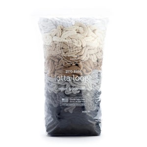 May include: A clear plastic bag filled with pro size "lotta loops" in a gradient of colors from white to dark gray. The bag has text that reads "makes 6 potholders" and "Quality cotton loops MADE IN THE USA".